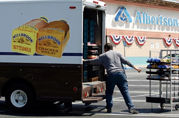 FILE - Mitch Maddox, a bread route salesman, loads bread Tuesday, May 30, 2006, outside the Eagle Rock Albertsons store in Los Angeles. Two of the nation's largest grocers have agreed to merge in a deal that would help them better compete with Walmart, Amazon and other major companies that have stepped into the grocery business. Kroger on Friday, Oct. 14, 2022 bid $20 billion for Albertsons Companies Inc., or $34.10 per share. (AP Photo/Damian Dovarganes, File)