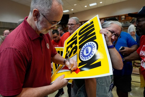 UAW president Shawn Fain signs an autograph for Volkswagen automobile plant employee Rachel Gleeson after workers voted to join the union Friday, April 19, 2024, in Chattanooga, Tenn. (AP Photo/George Walker IV)
